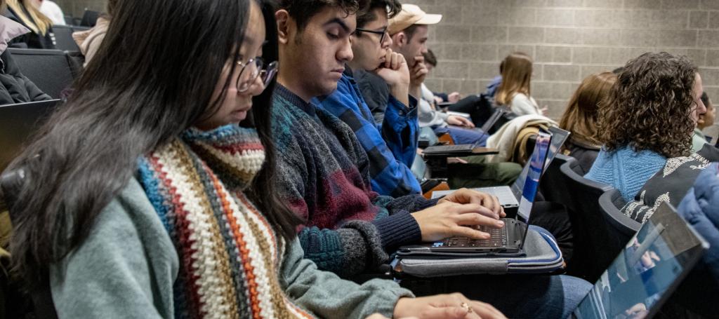 Students taking notes on their laptops in a course